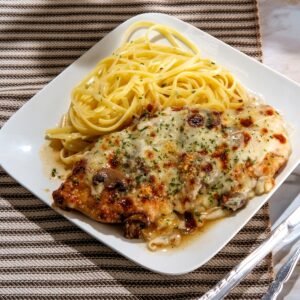 close up of chicken lombardy over pasta