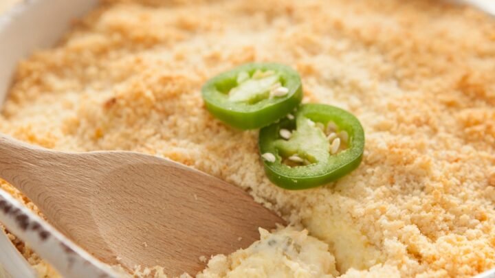 jalapeno popper dip in a white bowl with a wooden spoon