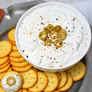 dirty martini dip garnished with olives and served with butter crackers