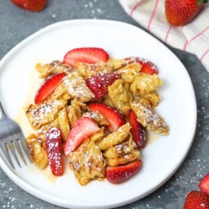 Scrambled Buttermilk Pancakes with Fresh Strawberries on a white plate