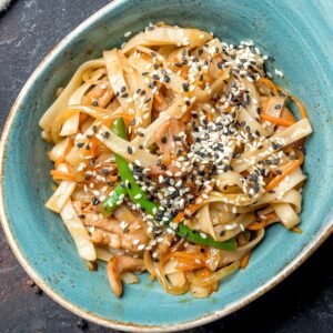 tahini noodles in a blue bowl